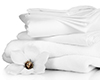 Stack of clean bedding sheets and towels isolated on white